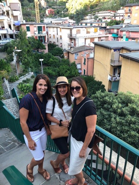 Three women standing on balcony in Monterosso, Italy