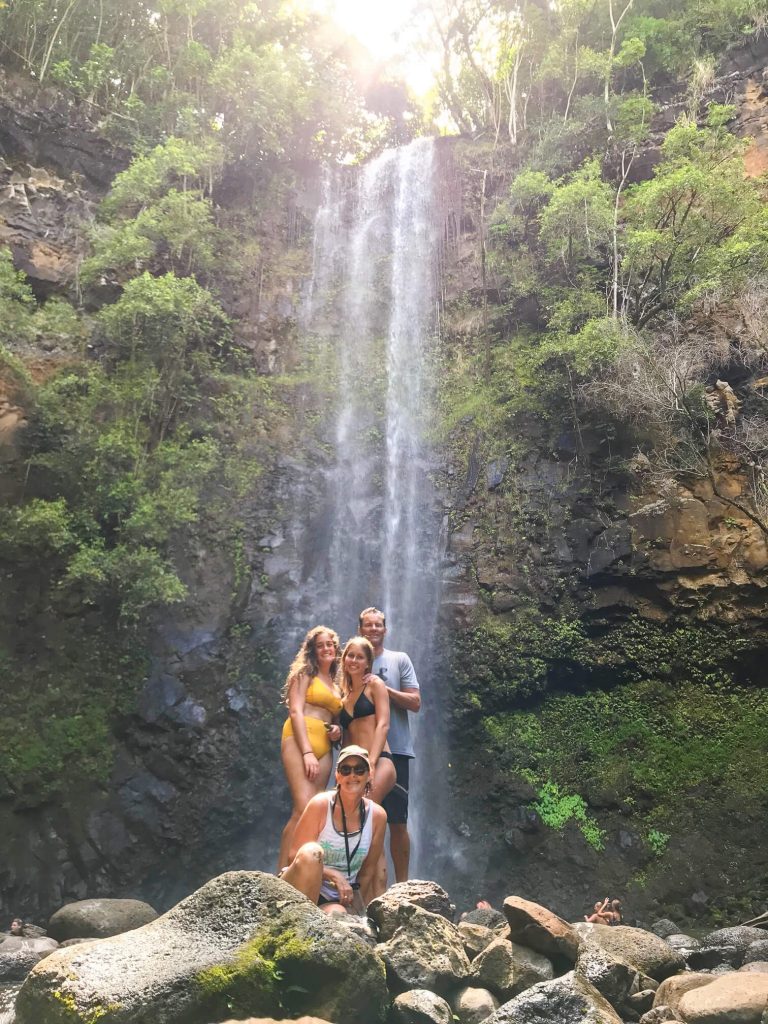 Four people under waterfall