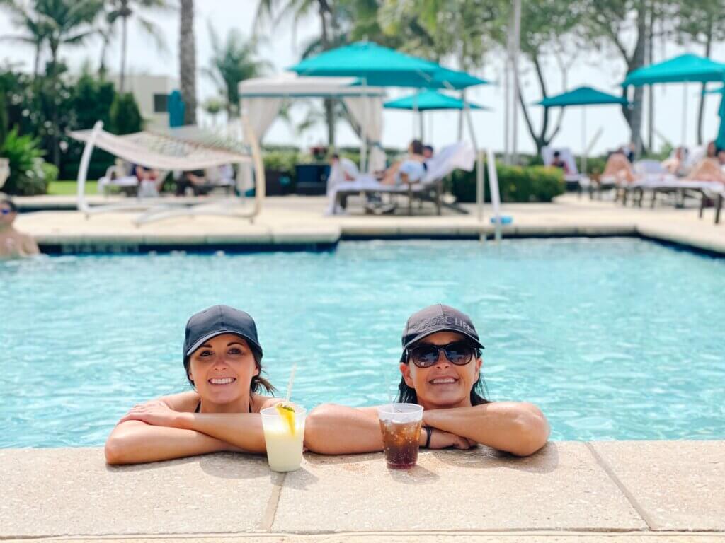 Two women with arms on side of pool