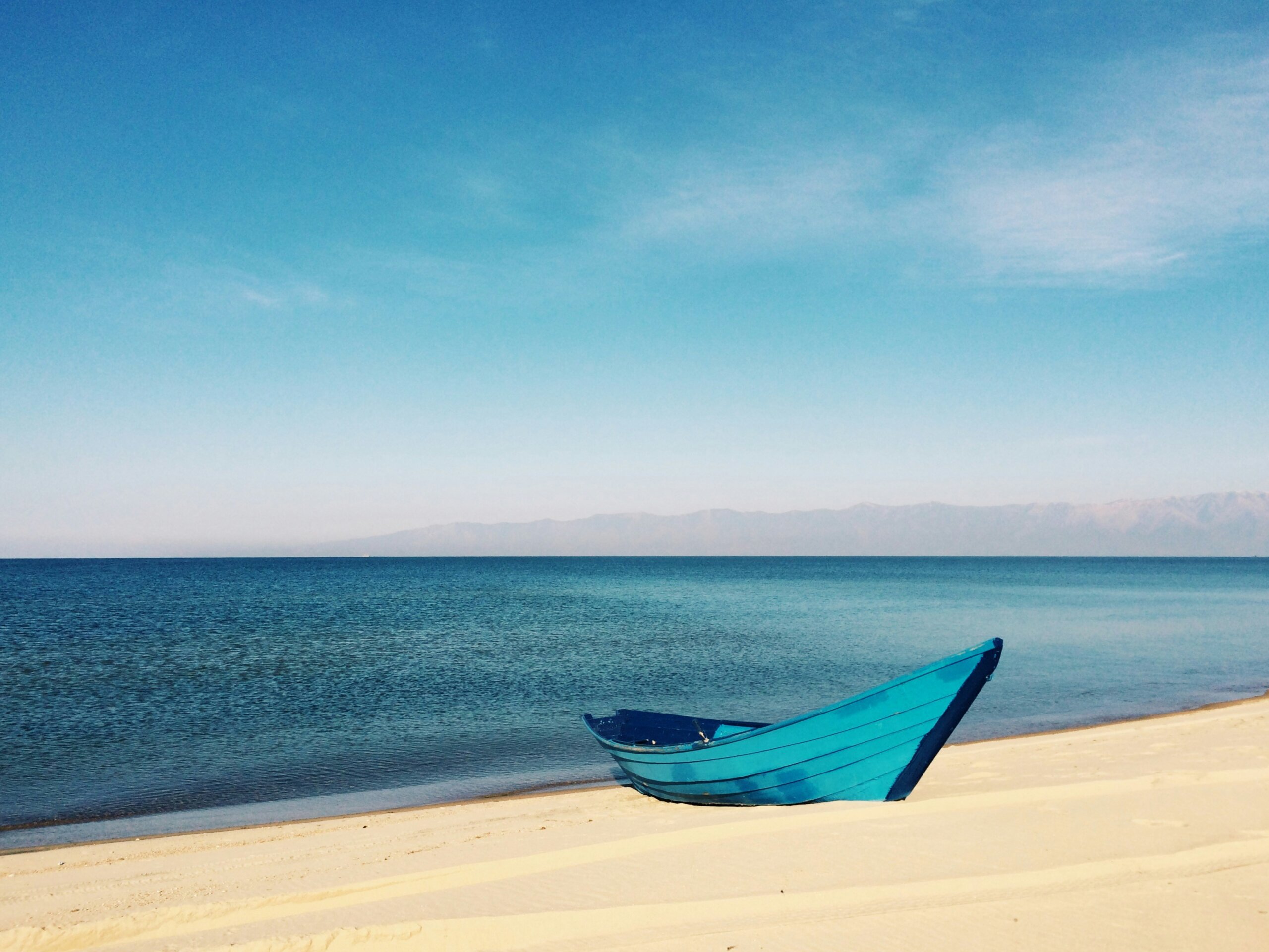 blue boat on sandy beach