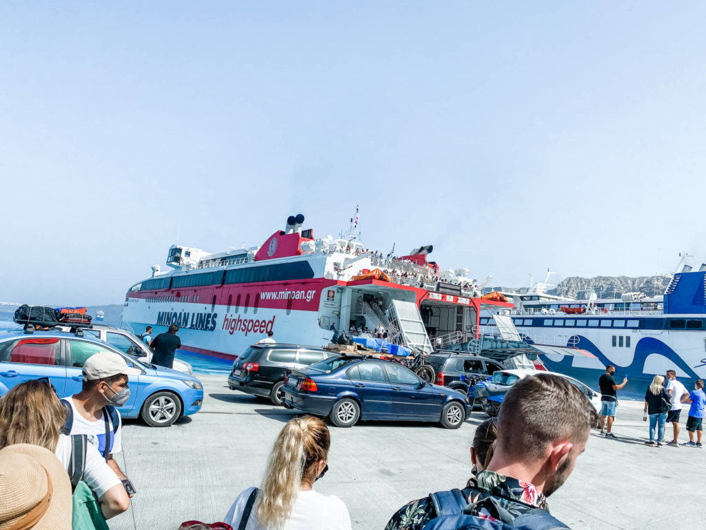 Red and white ferry with people waiting
