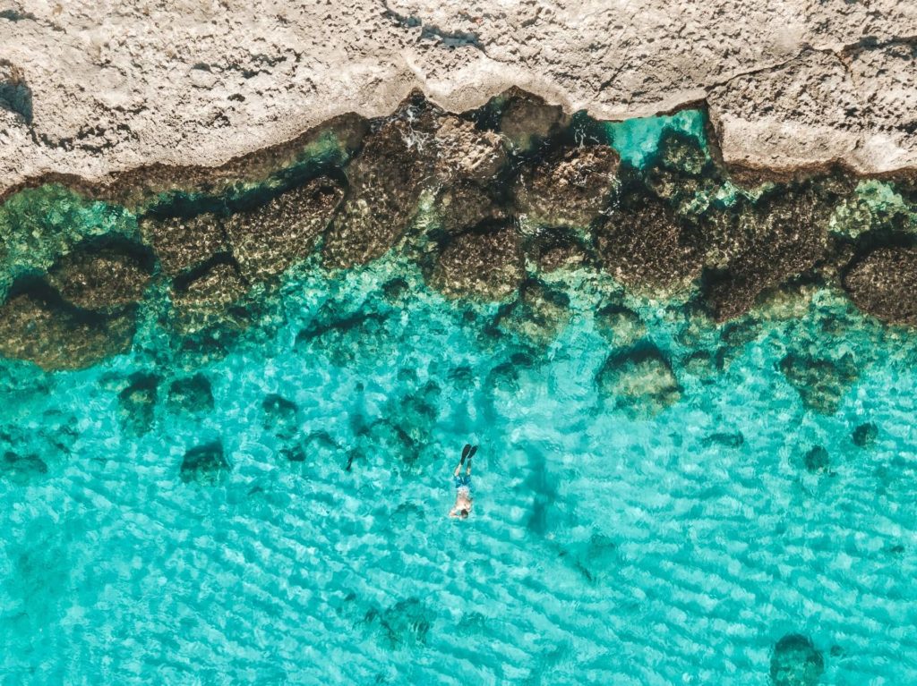 Turquoise water with person swimming in it