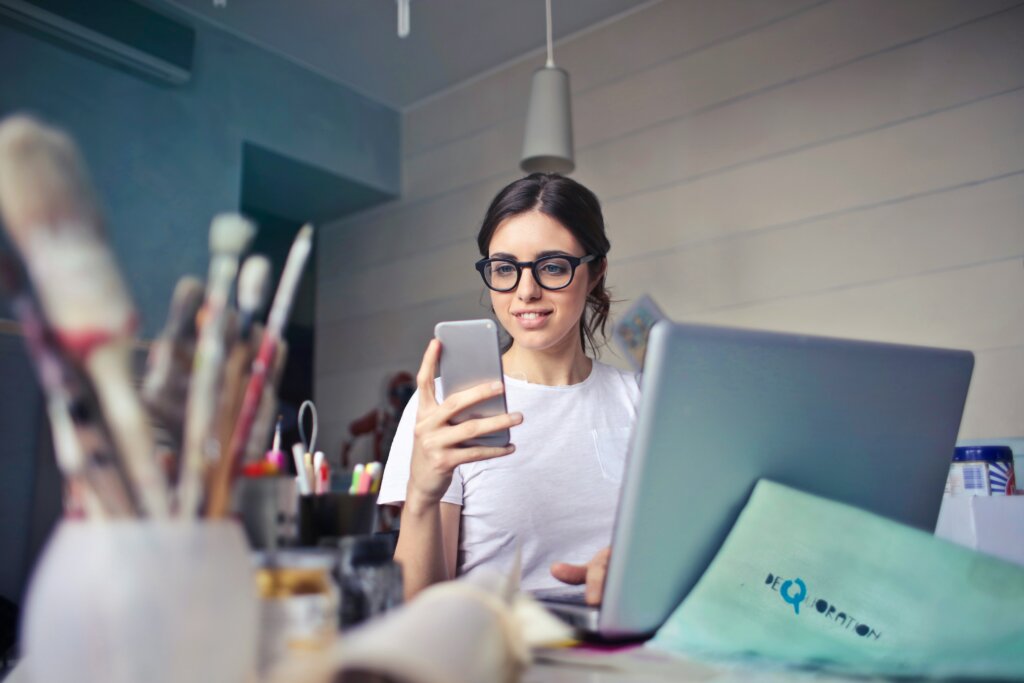 Girl looking at phone near computer