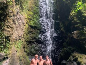 3 men in front of waterfall