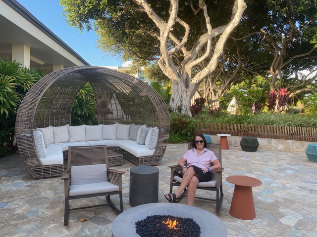 Woman sitting in chair by outdoor fire pit
