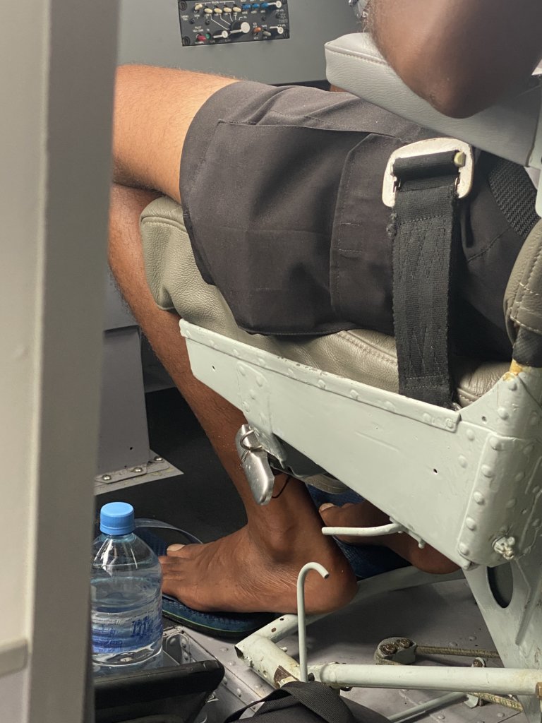 Man sitting in airplane seat without shoes
