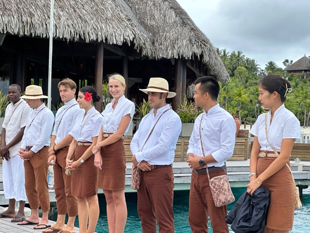 People standing on dock with brown pants and white shirts
