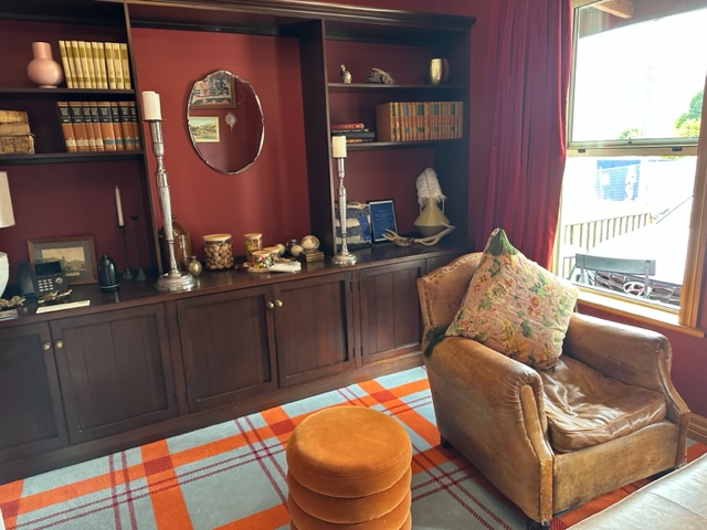 Library of hotel with blue and orange plaid rug.