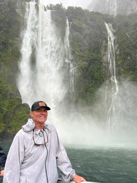 Man standing under waterfall