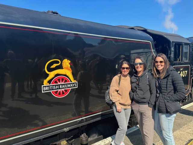 Three woman standing by black train