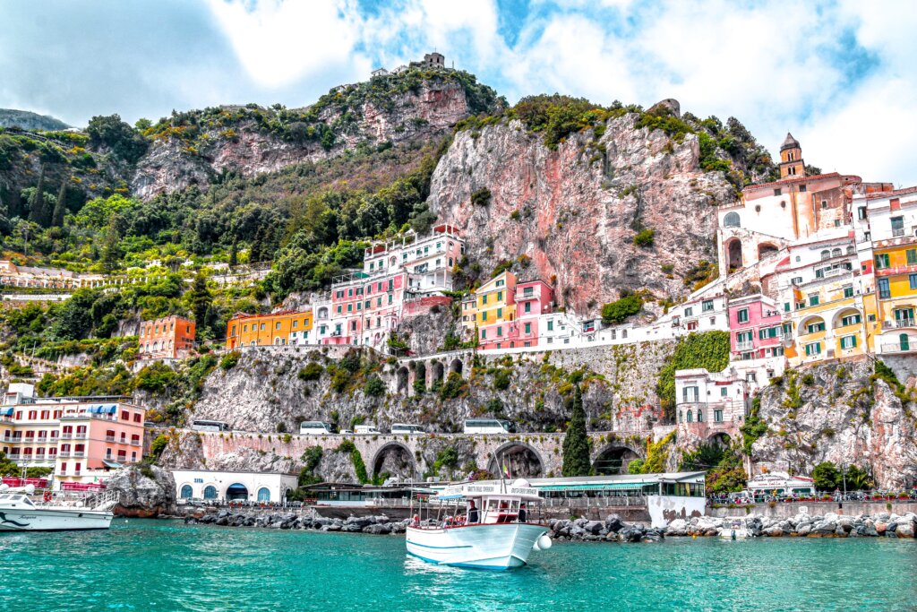 Colorful buildings along hill with turquoise water below