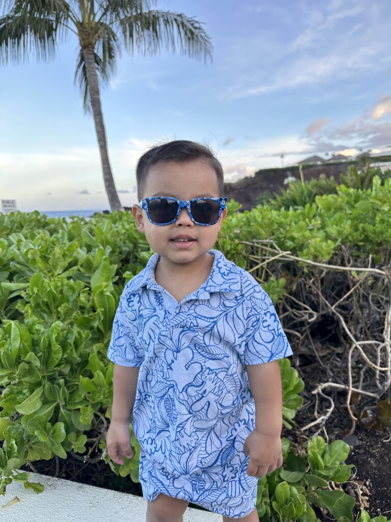 Little boy in blue shirt and sunglasses.