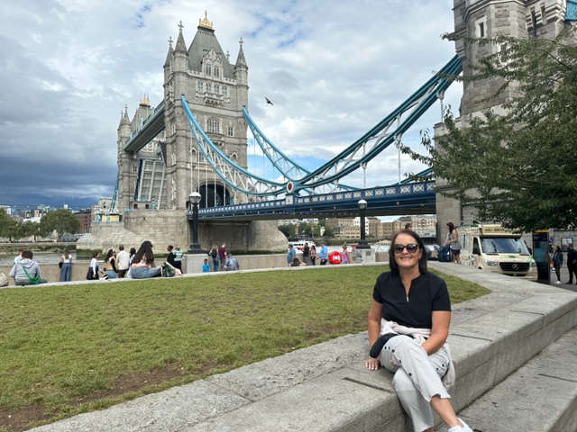 Woman sitting in front of tower bridge