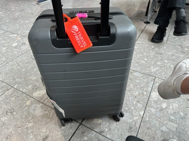 Grey Suitcase with orange luggage tag