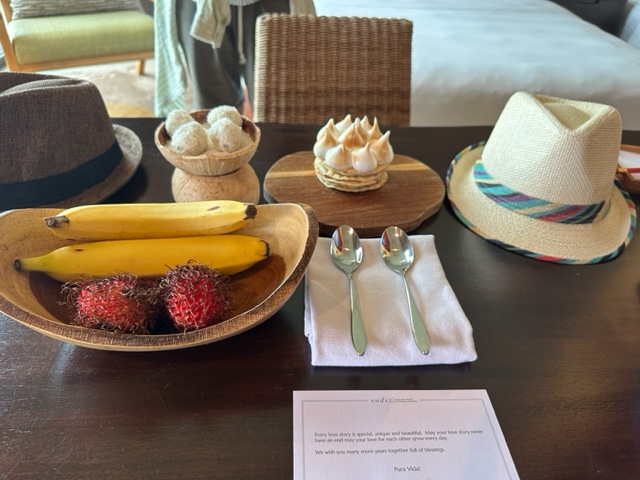 Fruit, meringue tart and fedoras on a table.