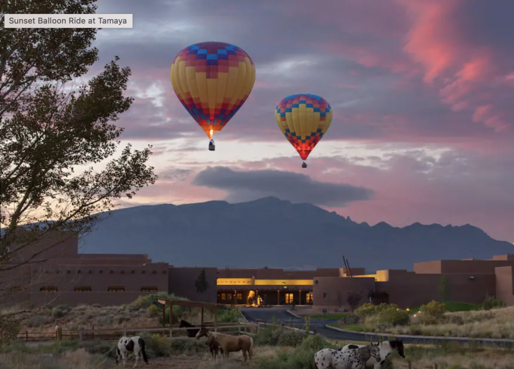 Hotel in desert with hot air balloon in sky