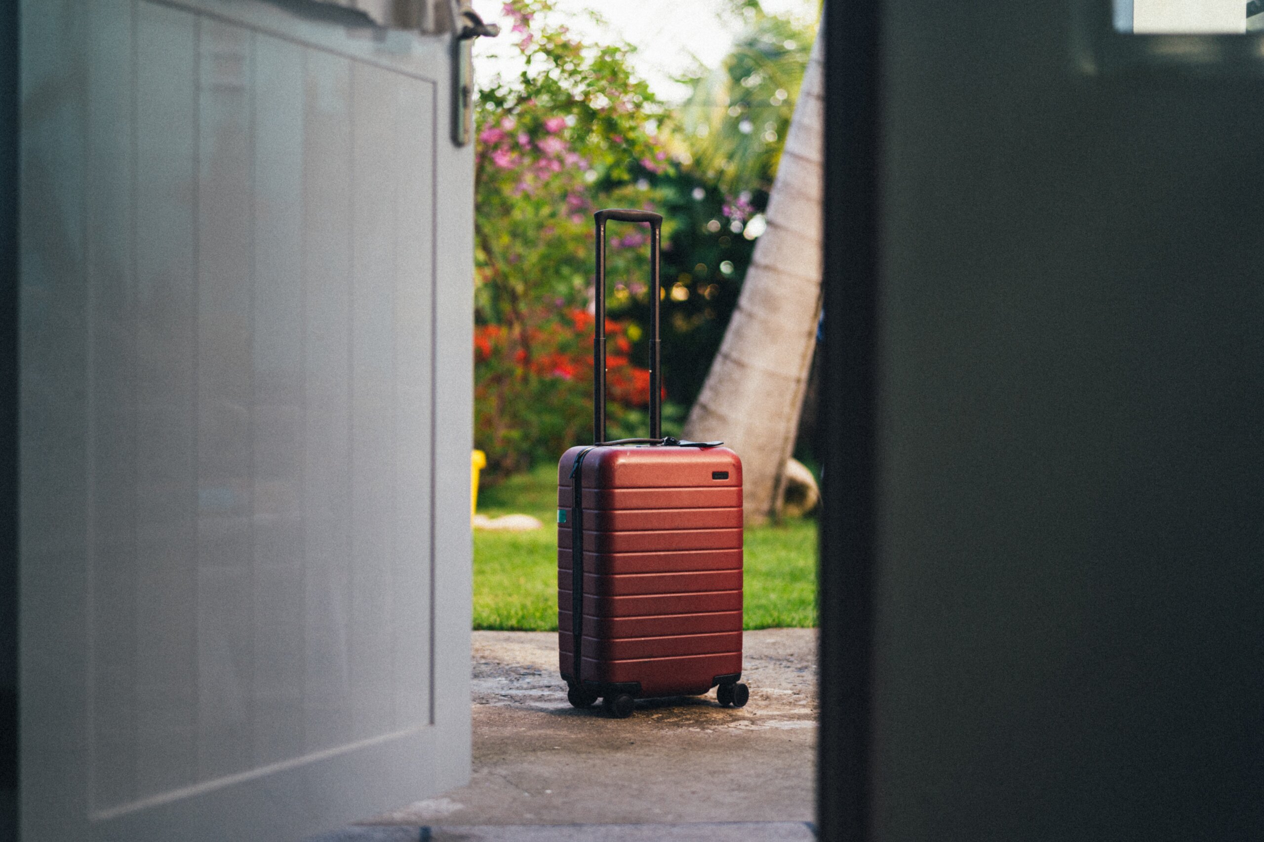 Brown upright suitcase outside doors