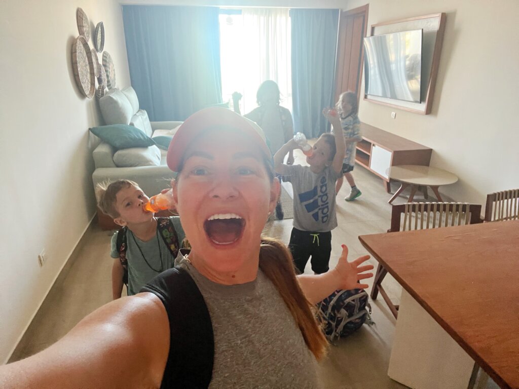 Woman and children delight in hotel room.