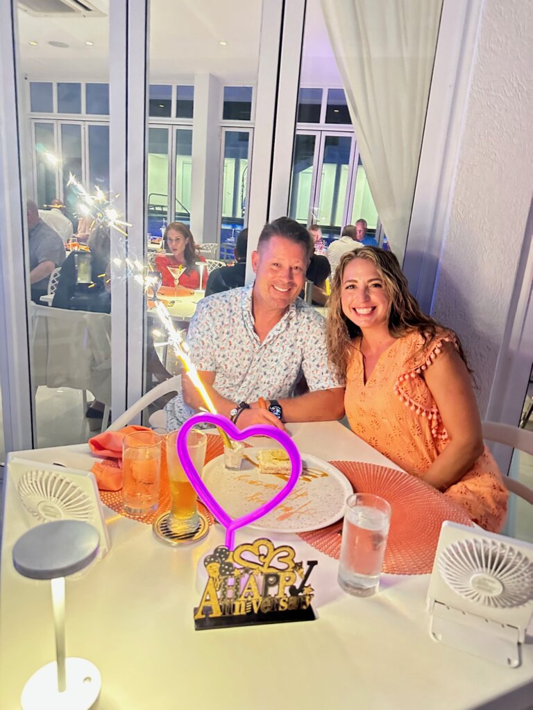Couple eating at table in restaurant - Travel Hacking Mom Reader Success Story to Aruba
