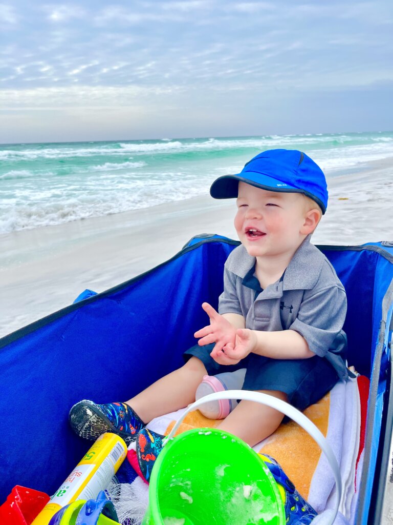 Little boy in blue ball cap near ocean
