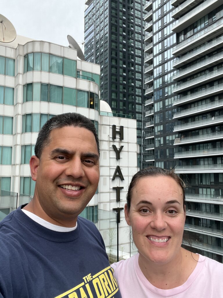 Man and woman standing in front of Hyatt sign.