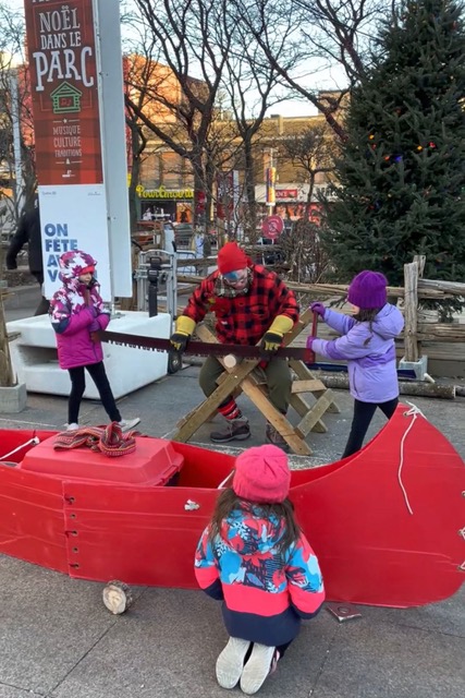 Montreal Christmas market, young girls sawing wood 