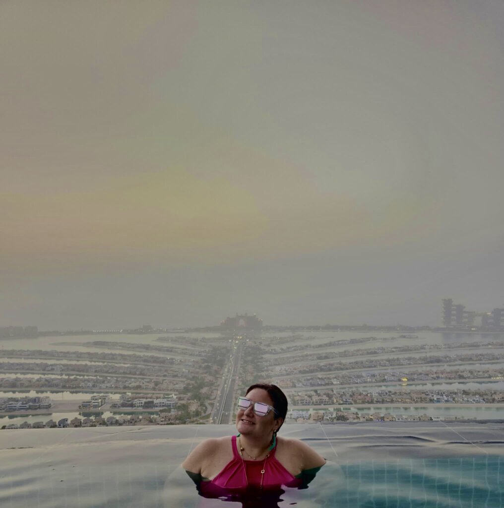 Woman in swimming pool at top of hotel