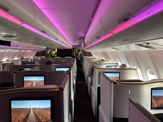 Airline business class seats with purple lights.