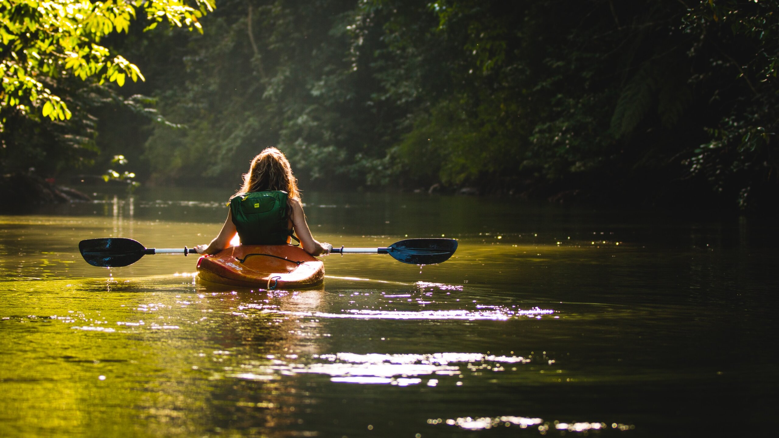 Girl paddling in river in jungle