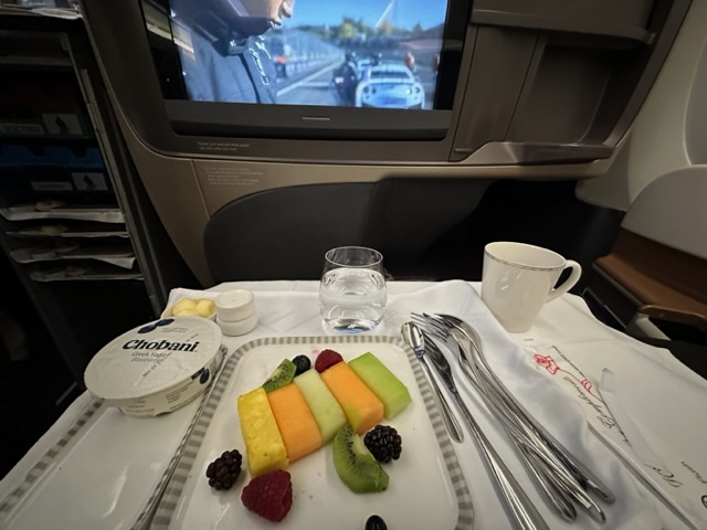 Fruit and yogurt on airplane table.