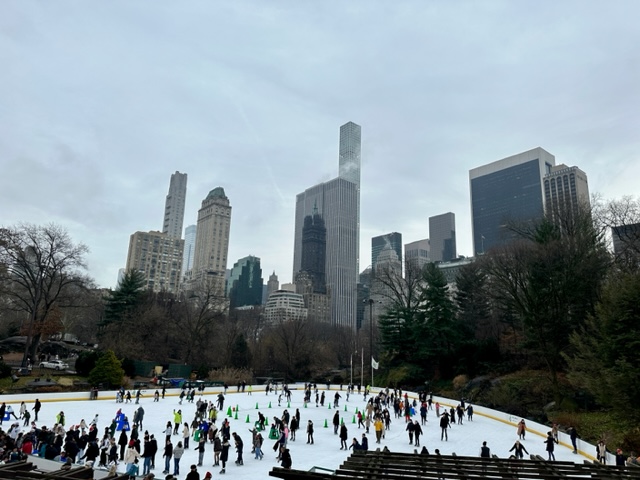 Ice skating rink with city skyscrapers in background
