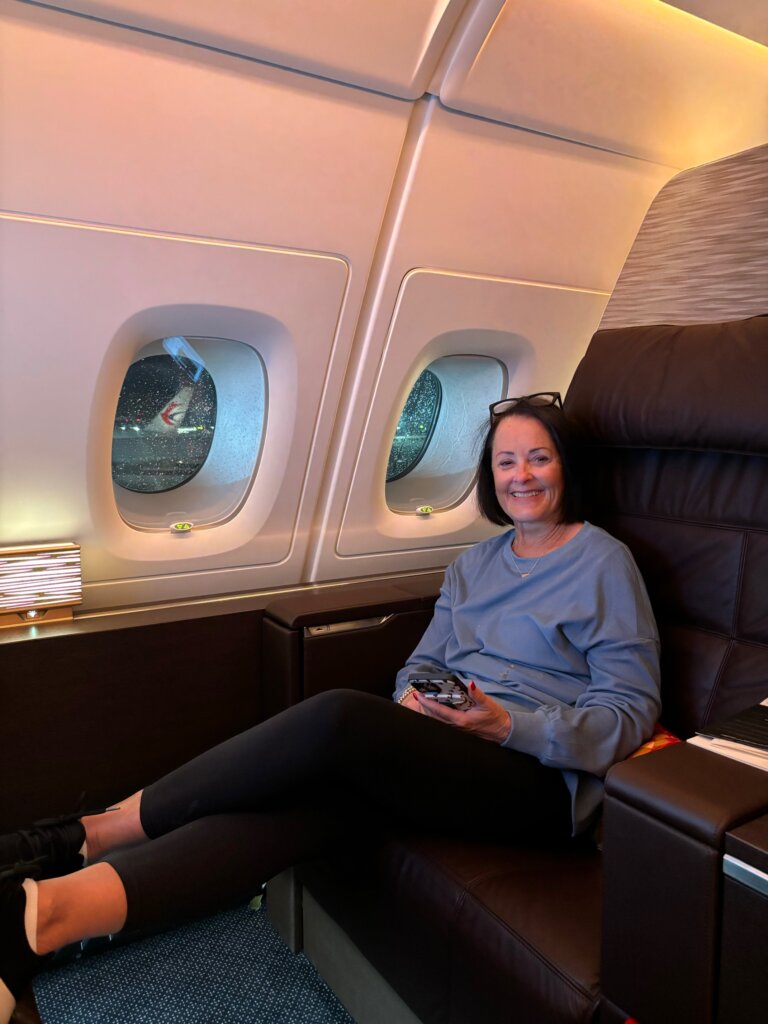 Woman sitting in lounge chair on airplane.