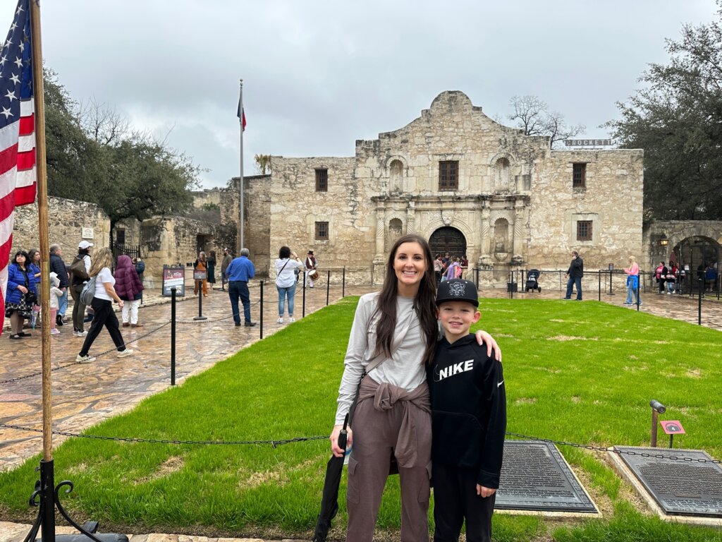 Woman and boy standing outside of cream colored fort.