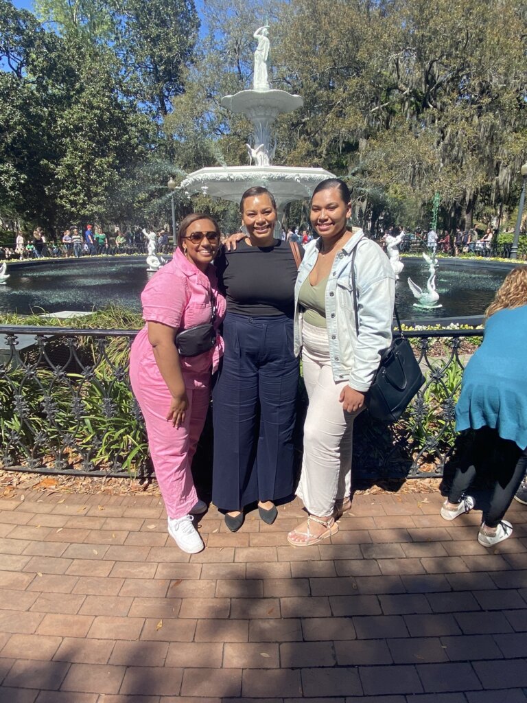 Three women standing in front of fountain