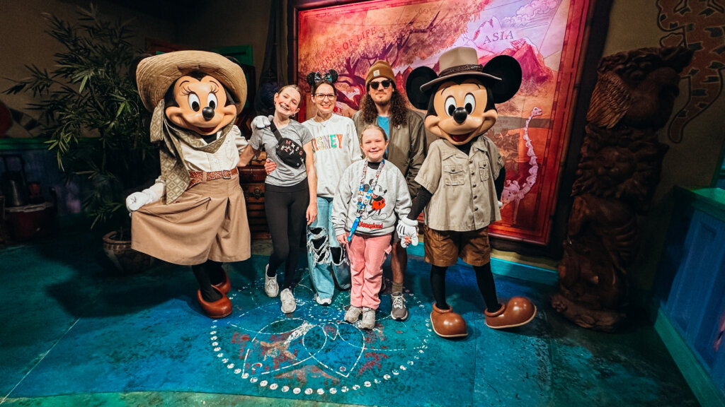 Emily of four with characters at a theme park.