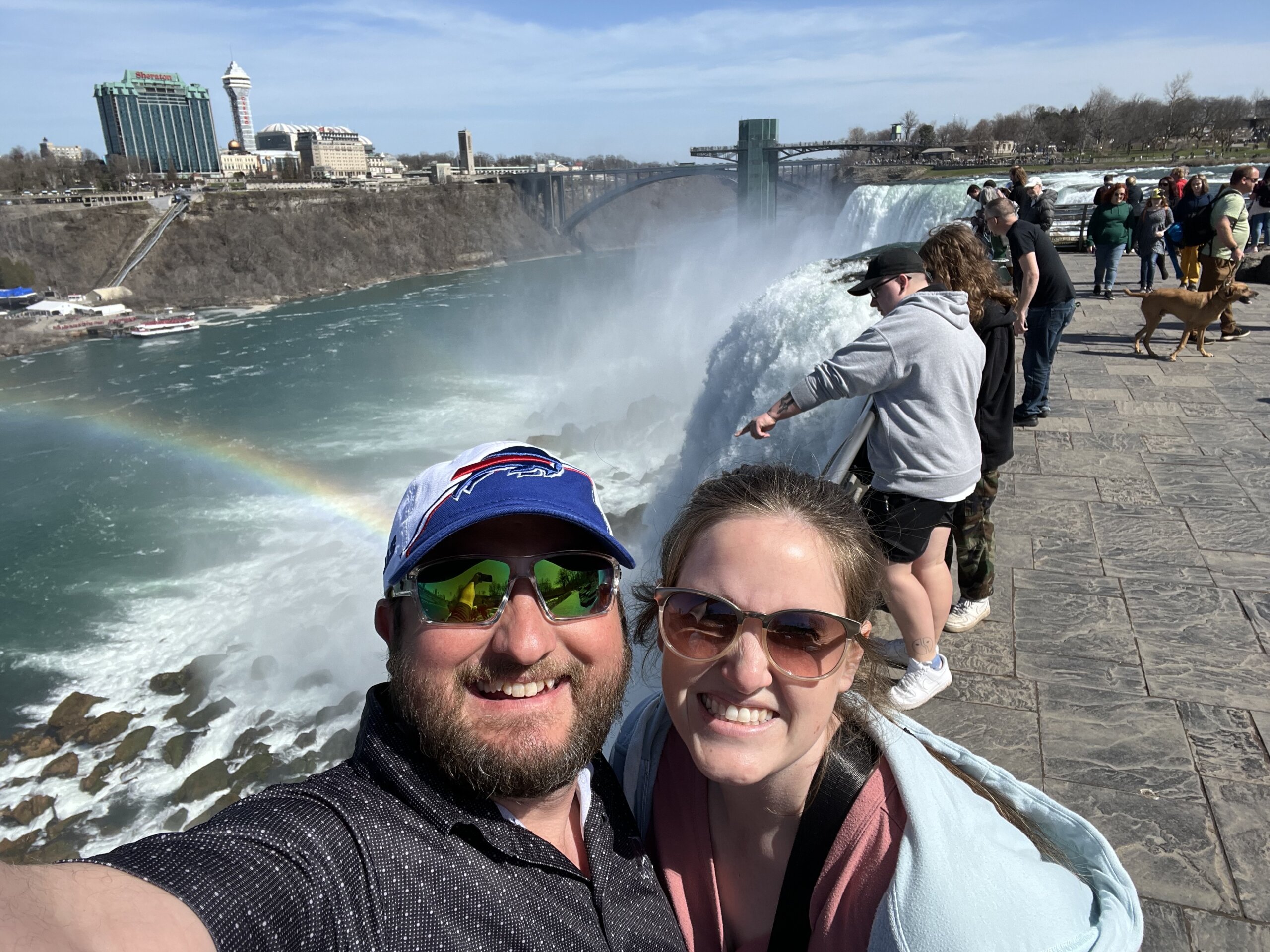 Man and woman standing near water falls