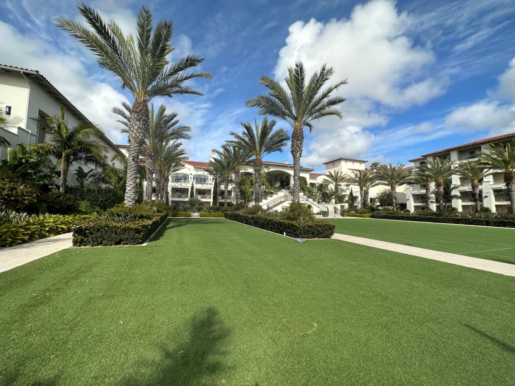 Grassy areas in front of white hotel.