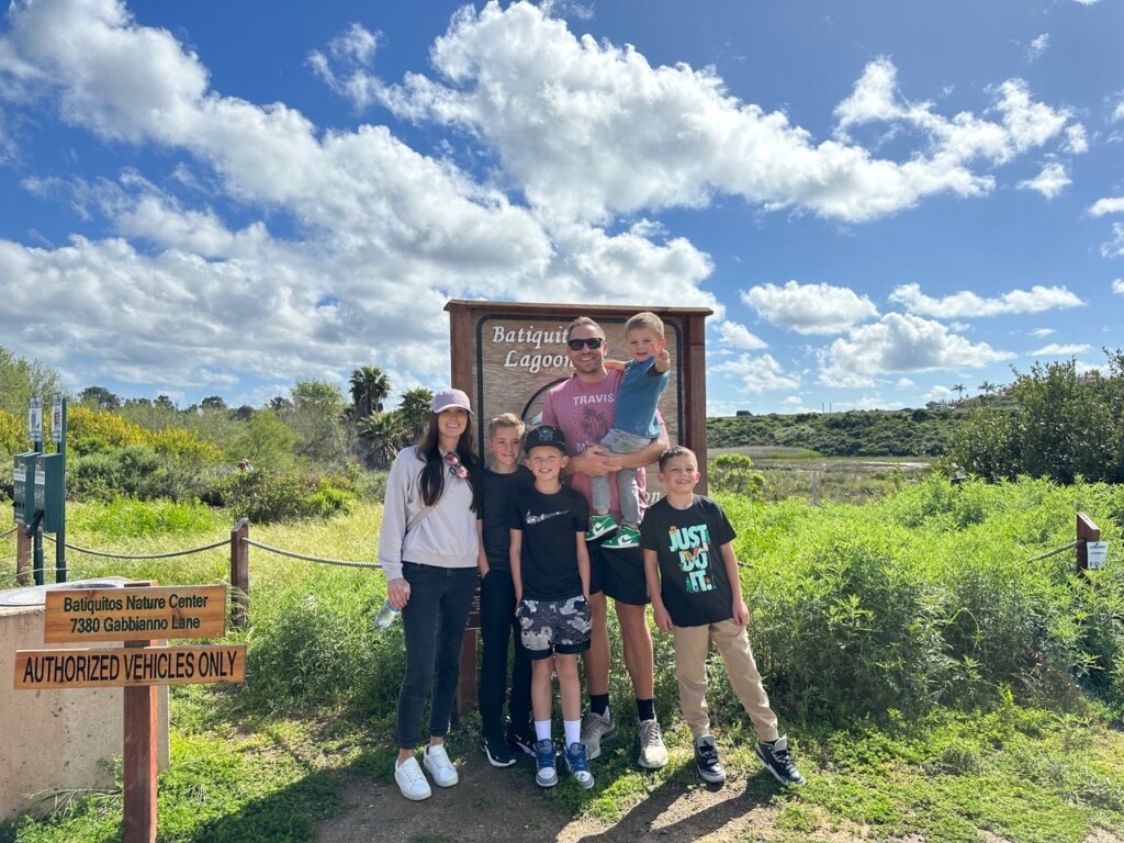 Family in front of sign on hiking trail