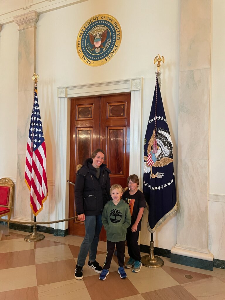 Woman and two boys by door with flags