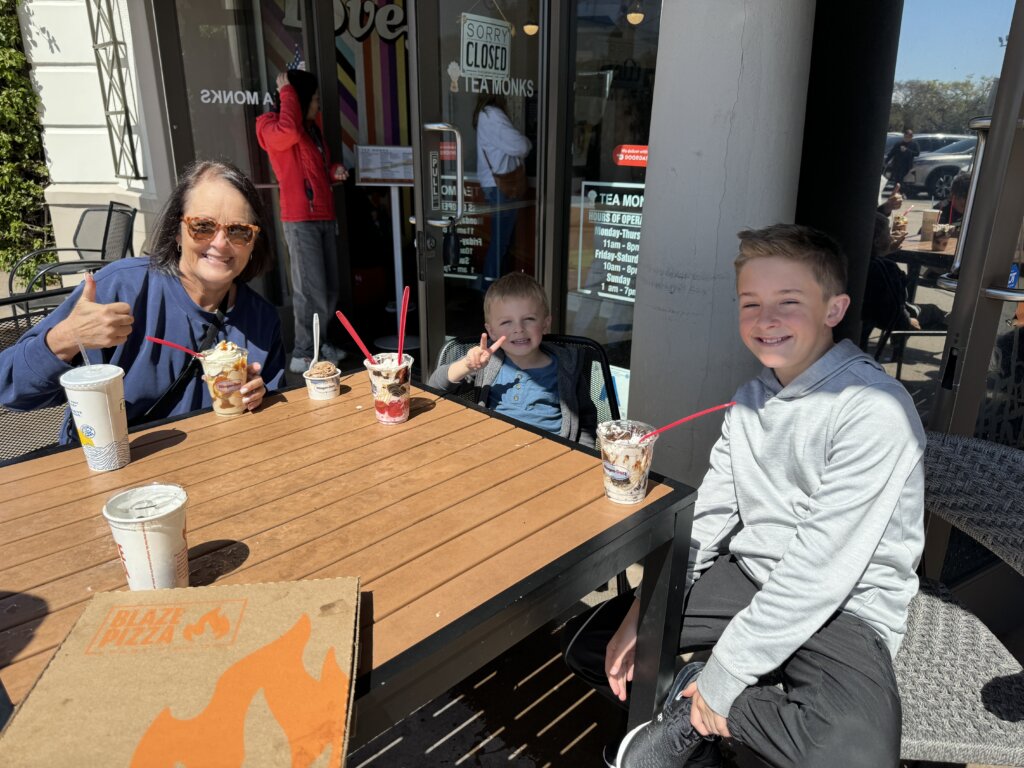 Women and two boys eating ice cream at outside table