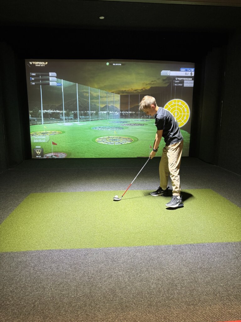 Boy at golf simulator