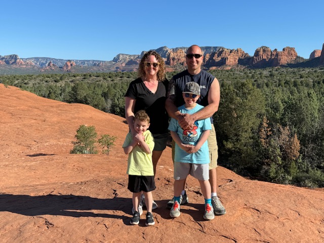 Family standing on red rock