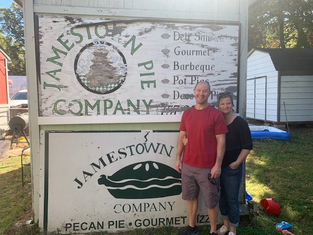 Man and women by Jamestown Company sign