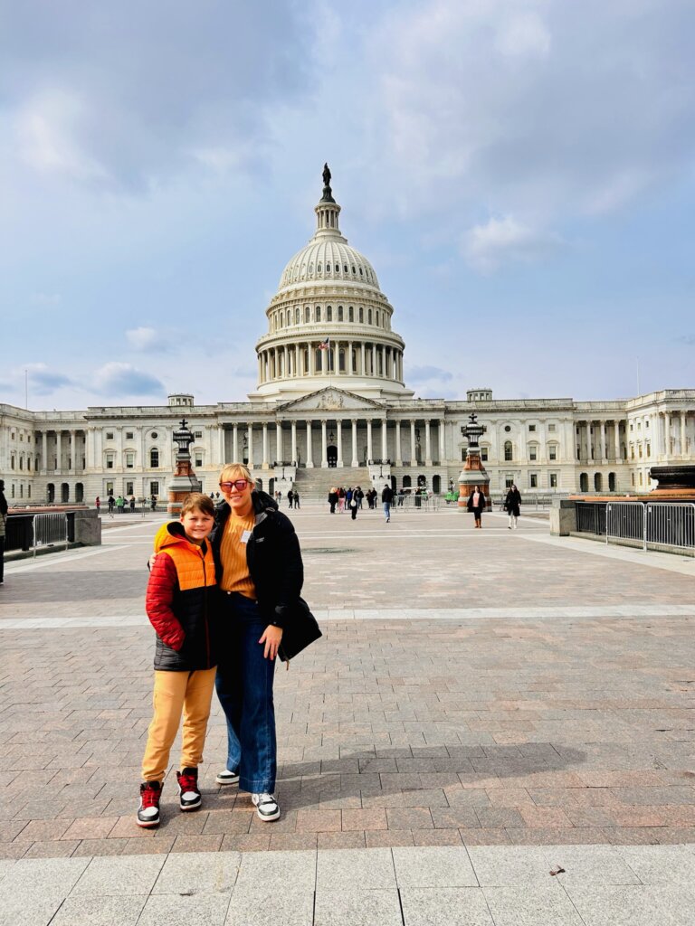 Women and boy in front of a historical building.