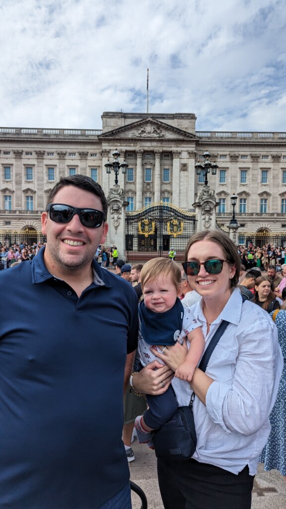 Man, woman and young child in front of old building.