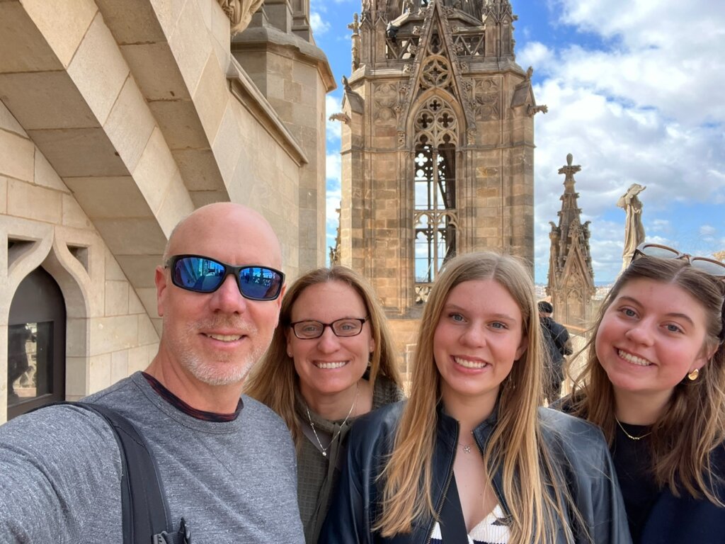 Family of four in front of large church.