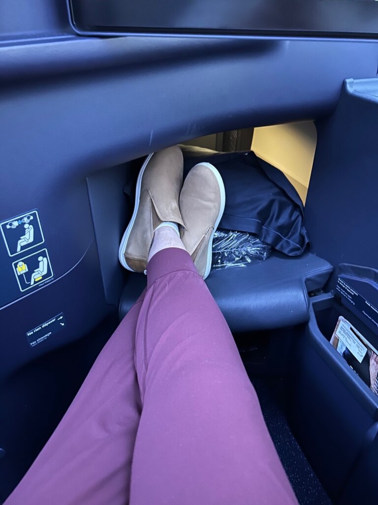 person with purple pants stretched out on plane