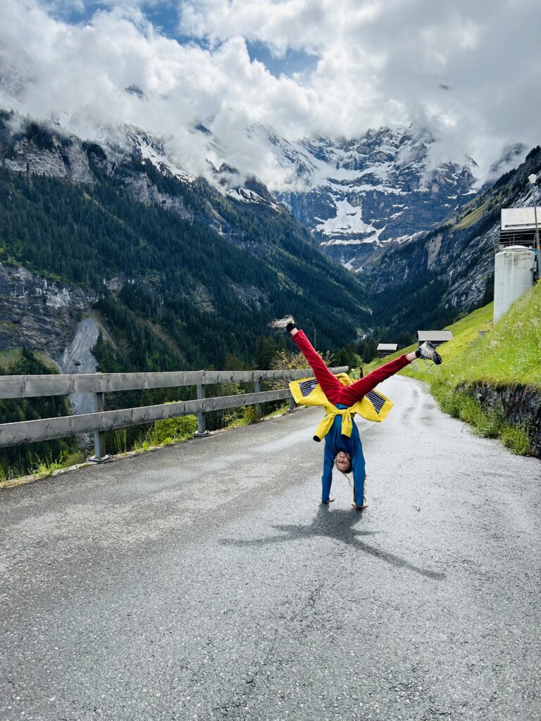 Child upside down on path in snow covered mountains