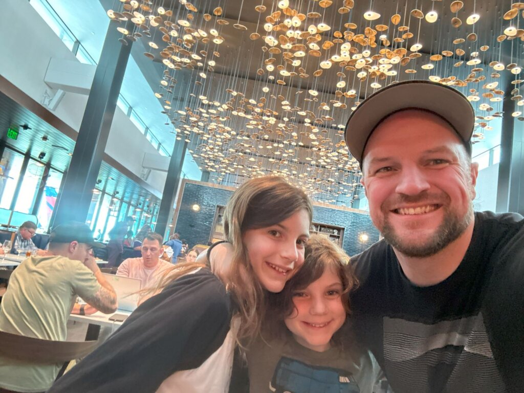 Man and two daughters in lounge.