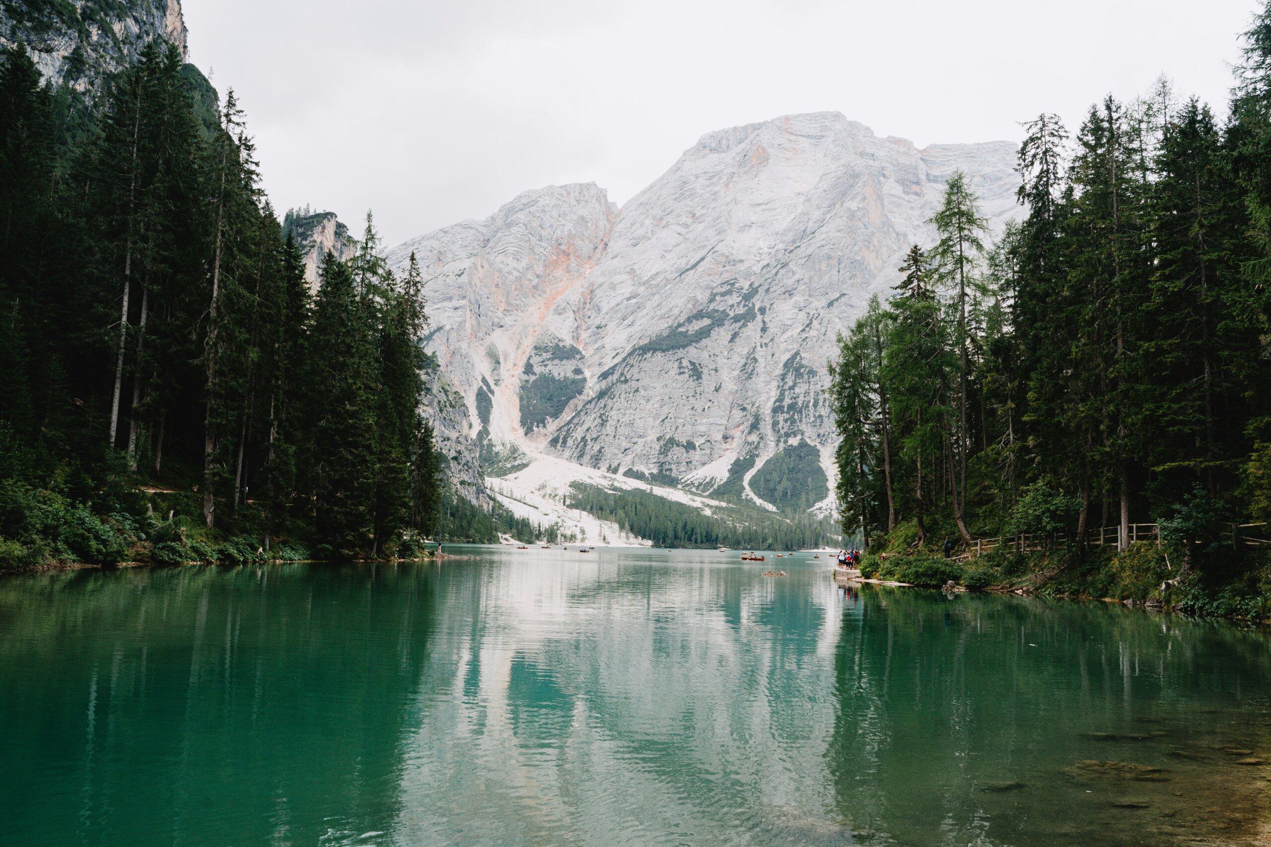 Blue-green lake nestled among trees and mountains